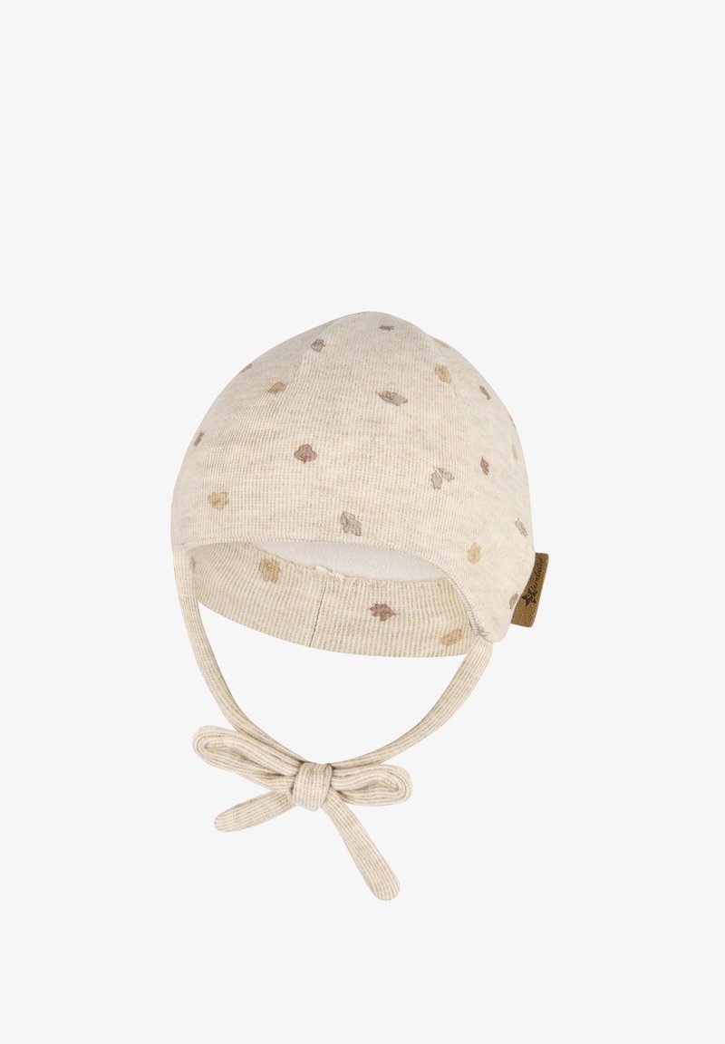 Knitted baby hat in light beige with a subtle pattern of brown spots, finished with a chin tie and a small, attached fabric label.