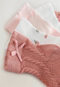 Keturių porų kojinių atspalviais rožinės ir baltos spalvos. Viena pora turi tekstūrinį raštą ir rožinę juostelę, kitos poros dekoruotos dryžuotais ir gėlių motyvais.