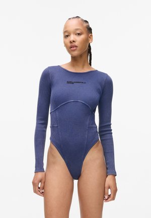 Navy ribbed bodysuit with long sleeves, scoop neck, and curved seams. Features front logo detail and high-cut legs. Smooth texture.