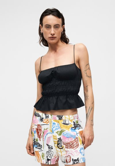 Μαύρο τοπ peplum με σμόκινγκ και λεπτές τιράντες, συνδυασμένο με πολύχρωμα σορτς που έχουν αφηρημένα σχέδια και εικονογραφήσεις σε ελαφρύ ύφασμα.