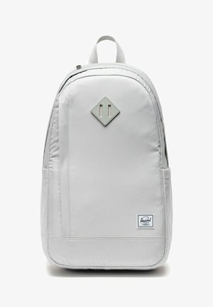 Sac à dos Herschel gris clair avec patch en forme de losange à l'avant, poignée supérieure, compartiment principal zippé et étiquette de marque en bas à droite.