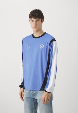 Light blue long-sleeve shirt with black accents, features white sleeves and a logo on the chest. Made of smooth fabric, relaxed fit.