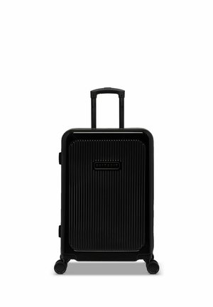 Black hard-shell suitcase with vertical ribbed texture, extendable handle, and four wheels for mobility. Brand logo displayed on front.