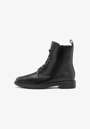 Bocanci negri din piele, la gleznă, cu șireturi, vârf rotunjit, tag la spate și talpă plată din cauciuc. Textură netedă și design minimalist.