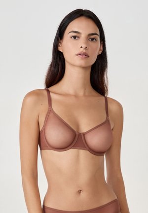 Bra in Braun mit Unterdraht, der durchsichtige Mesh-Cups, verstellbare Träger und ein glattes Band bietet. Entwickelt für einen angepassten, strukturierten Look.