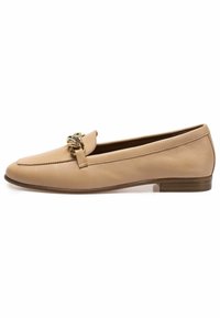 Mocasines de cuero beige con tacón plano, que presentan una cadena dorada decorativa en la parte delantera. Textura suave, diseño minimalista.