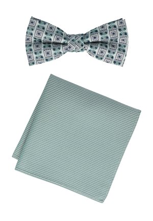 Eine Fliege mit einem bunten geometrischen Muster in Grün und Marineblau auf einem hellen Hintergrund, kombiniert mit einem strukturierten, einfarbigen mintgrünen Taschentuch.