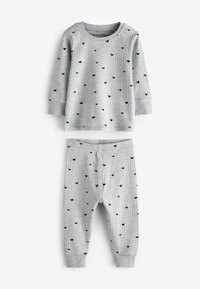Top a maniche lunghe grigio a coste e pantaloni coordinati, con piccoli motivi a cuore neri, dotati di polsini sulle maniche e sulle caviglie per una vestibilità aderente.