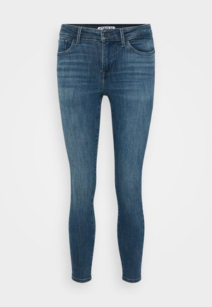 Skinny jeans in donkerblauwe denim met een vervaagde textuur. Heeft een middelhoge taille, vijf zakken en een sluiting met één knoop.