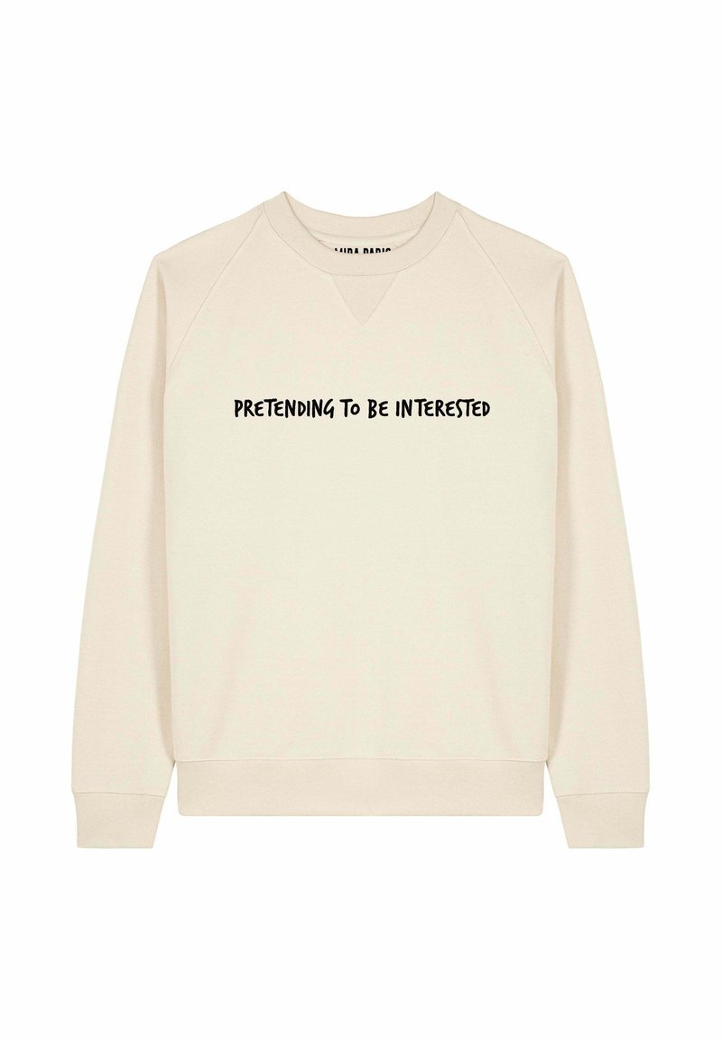 Felpa beige chiaro con scollatura a V e maniche raglan. Presenta il testo "FINGENDO DI ESSERE INTERESSATI" in grassetto nero sul petto.