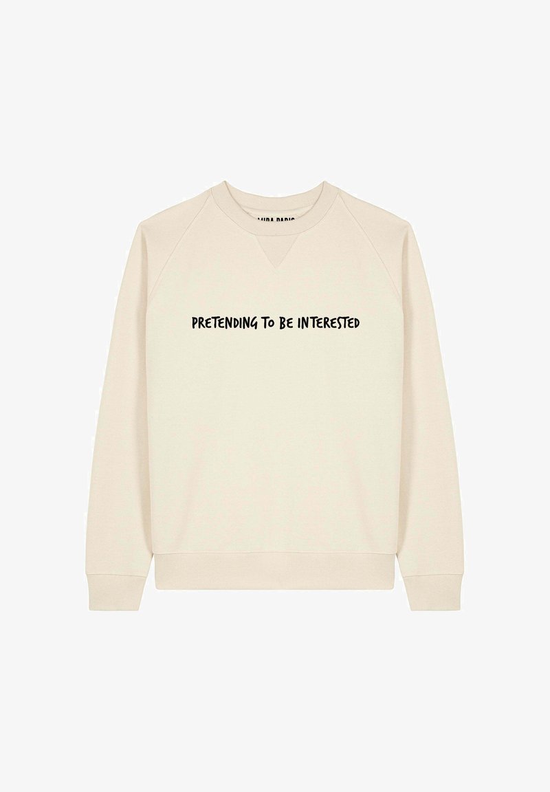 Felpa beige chiaro con scollatura a V e maniche raglan. Presenta il testo "FINGENDO DI ESSERE INTERESSATI" in grassetto nero sul petto.