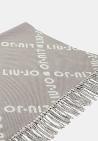 Couverture en tissu gris texturé avec des bords frangés, arborant un motif répété du logo "Liu Jo" en blanc sur toute sa surface.
