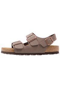 Sandalias Birkenstock marrones con dos correas ajustables, plantilla suave, media suela de corcho y suela exterior de goma texturizada.