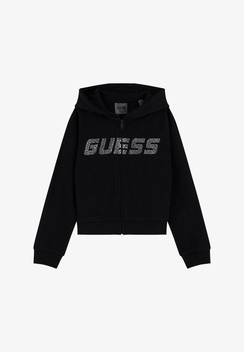 Sweat à capuche noir avec fermeture éclair, capuche et manches longues, arborant "GUESS" en strass argentés sur la poitrine.