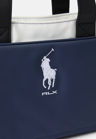 Saco de tote azul-marinho com um exterior liso e impermeável, detalhes em preto e logótipo bordado RLX em branco, apresentando um jogador de polo.
