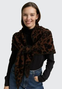 Châle en imprimé animal marron et noir, fabriqué en tissu doux et texturé, drapé sur les épaules, avec des extrémités pointues et une finition moelleuse.