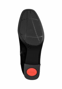 Crna potplat cipela s teksturiranim gumenim gaznim slojem sa dijamantnim uzorkom, crvenim logotipom udobnosti na peti i glatkim crnim rubom.