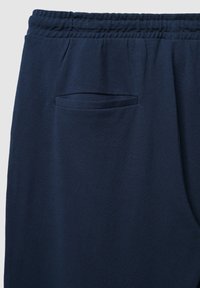 Marineblaue Sweatpants mit strukturiertem Stoff, elastischem Bund und einer einzelnen Tasche an der Seite zur Aufbewahrung.