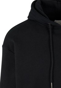 Sweat à capuche en coton noir avec capuche à cordon de serrage et étiquette intérieure visible, montré de l'épaule au cou.