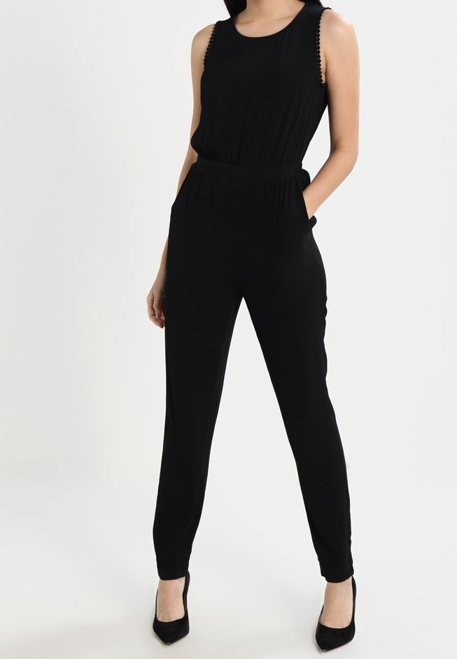 Černý overal bez rukávů, se staženým pasem a bočními kapsami. Má strukturovaný lem podél ramen a zúžené nohavice.
