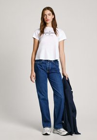 Valge lühikeste varrukatega särk musta "Pepe Jeans London" logo, sinised otseöödeldud teksad, hallid tossud, hoiab käes tumesinist triibulist bleiserit.