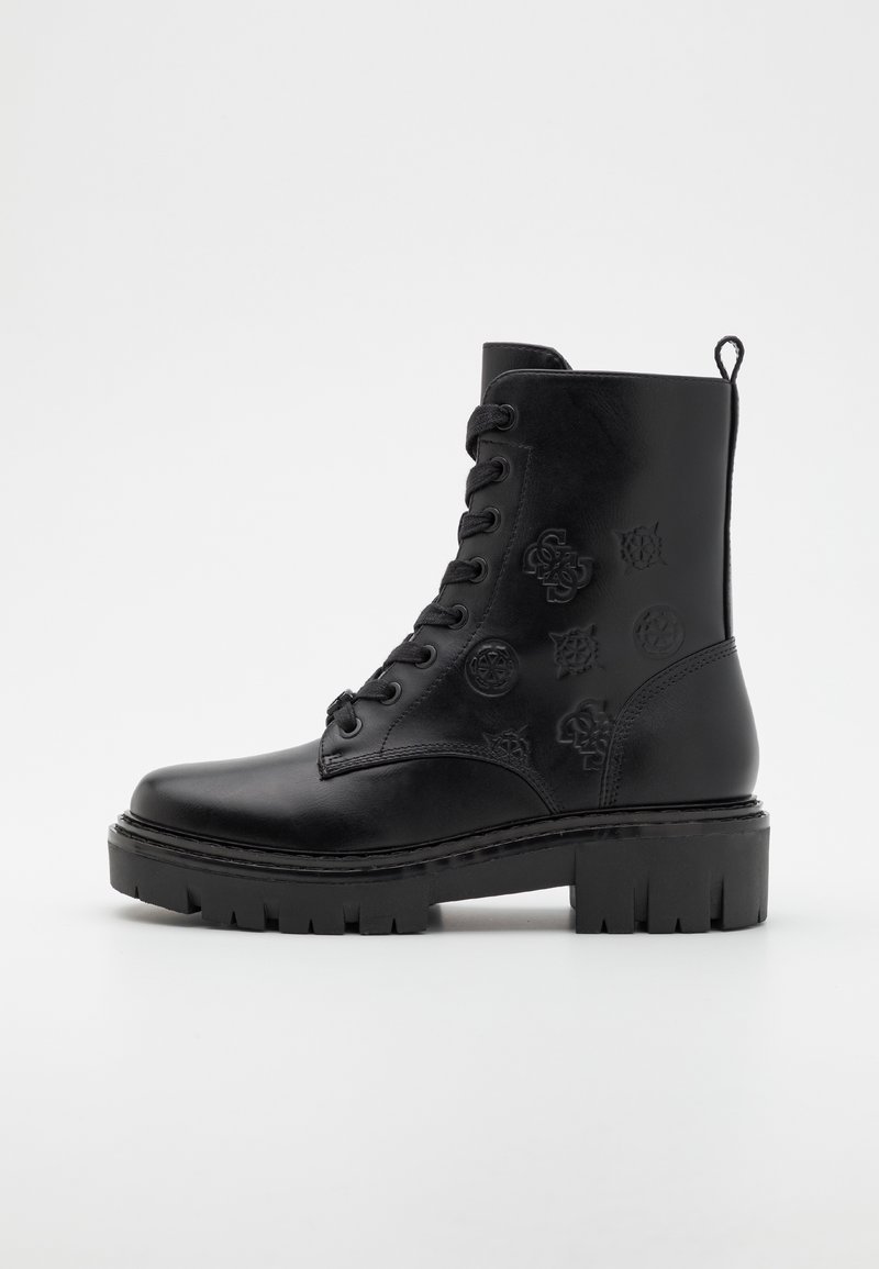 Botte de combat en cuir noir à lacets avec semelle épaisse à crampons et logos décoratifs embossés sur le panneau latéral.