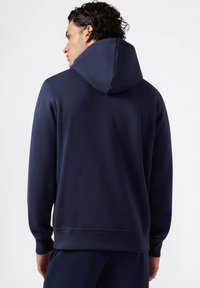 Felpa con cappuccio blu navy con superficie testurizzata, polsini a coste e tasca a marsupio. Presenta una vestibilità comoda e un cappuccio regolabile.