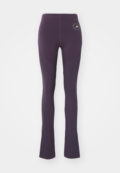 Högmidjade mörk lila leggings med ribbad knädetalj och en liten cirkulär logotyp på den övre vänstra låret.