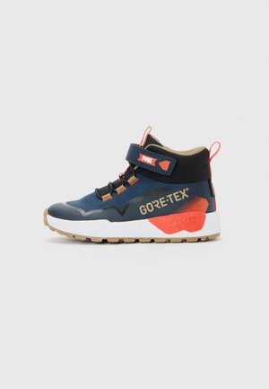 Dark blue and black Gore-Tex high-top sneaker with white sole, orange accents, pull tabs, and Velcro strap on plain background.
