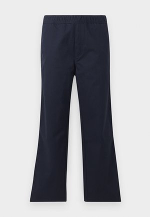 Sötétkék, kivágott nadrág sima anyagból. Rugalmas derékrésszel és oldalsó zsebekkel rendelkezik. Tiszta vonalak és minimalista dizájn jellemzi.