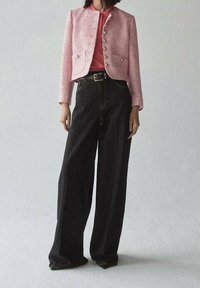 Lyserød tekstureret jakke med sølvknapper, parret med højtaljede sorte buksestropper med bred ben. Enkel design, ensfarvede farver, ingen mønstre.