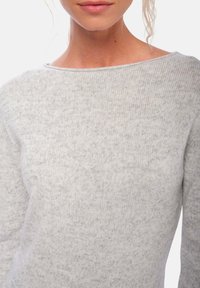 Pull gris clair avec un col rond et une texture côtelée, doté de manches longues et en matériau tricoté doux.