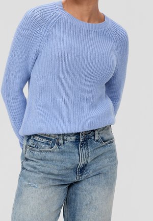 Pull en maille bleu clair avec une texture côtelée, col rond et manches raglan, associé à un jean en denim bleu délavé.