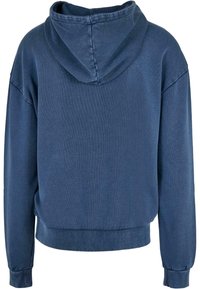 Felpa con cappuccio di colore blu scuro, realizzata in tessuto morbido. Caratterizzata da una vestibilità comoda, spalle ribassate e polsini a costine. Tessuto liscio con dettagli minimi.