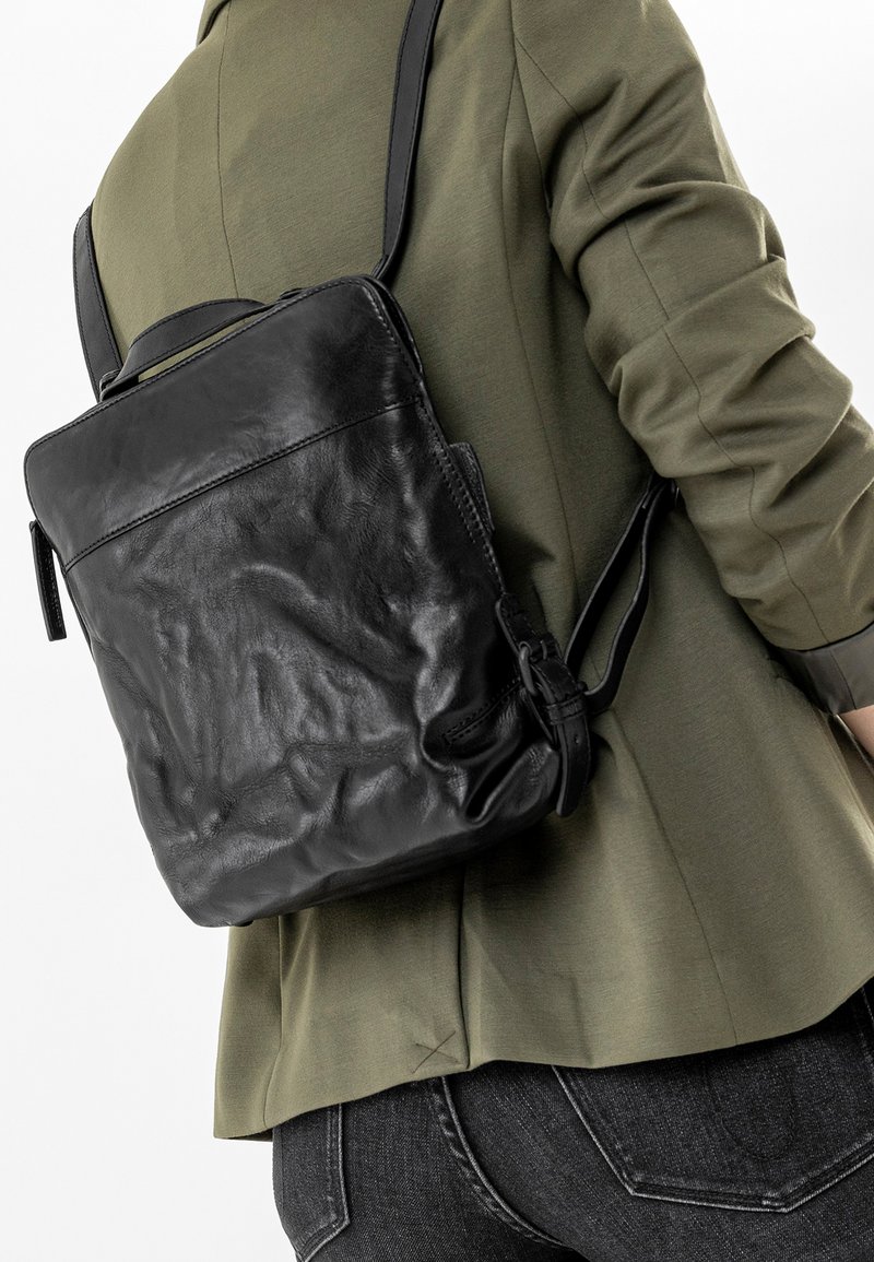 Zaino in pelle nera con forma rettangolare, dotato di un manico corto e di una tracolla regolabile, con una superficie texture.