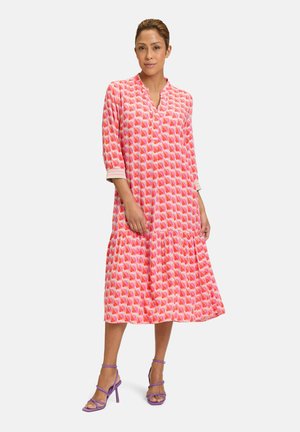 Rosa gemustertes Kleid mit einem auslaufenden Saum, Dreiviertelärmel und V-Ausschnitt. Verfügt über ein geometrisches Design und einen leichten Stoff.