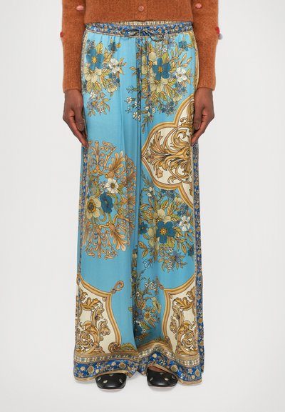 Pantalons larges bleu clair avec motifs floraux en or, blanc et bleu, avec une bordure à motifs et une taille élastique avec cordon de serrage.