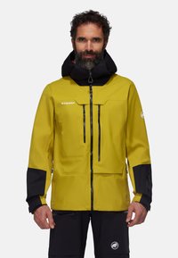 Giacca impermeabile gialla con accenti neri, caratterizzata da un colletto alto, tasche con zip e cappuccio regolabile. Tessuto resistente con una consistenza liscia.