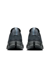 Chaussures de sport avec une tige en mesh gris foncé, des talons renforcés et une semelle intermédiaire texturée. Dotées d'une languette de tirage bleue et d'un logo sur le talon.