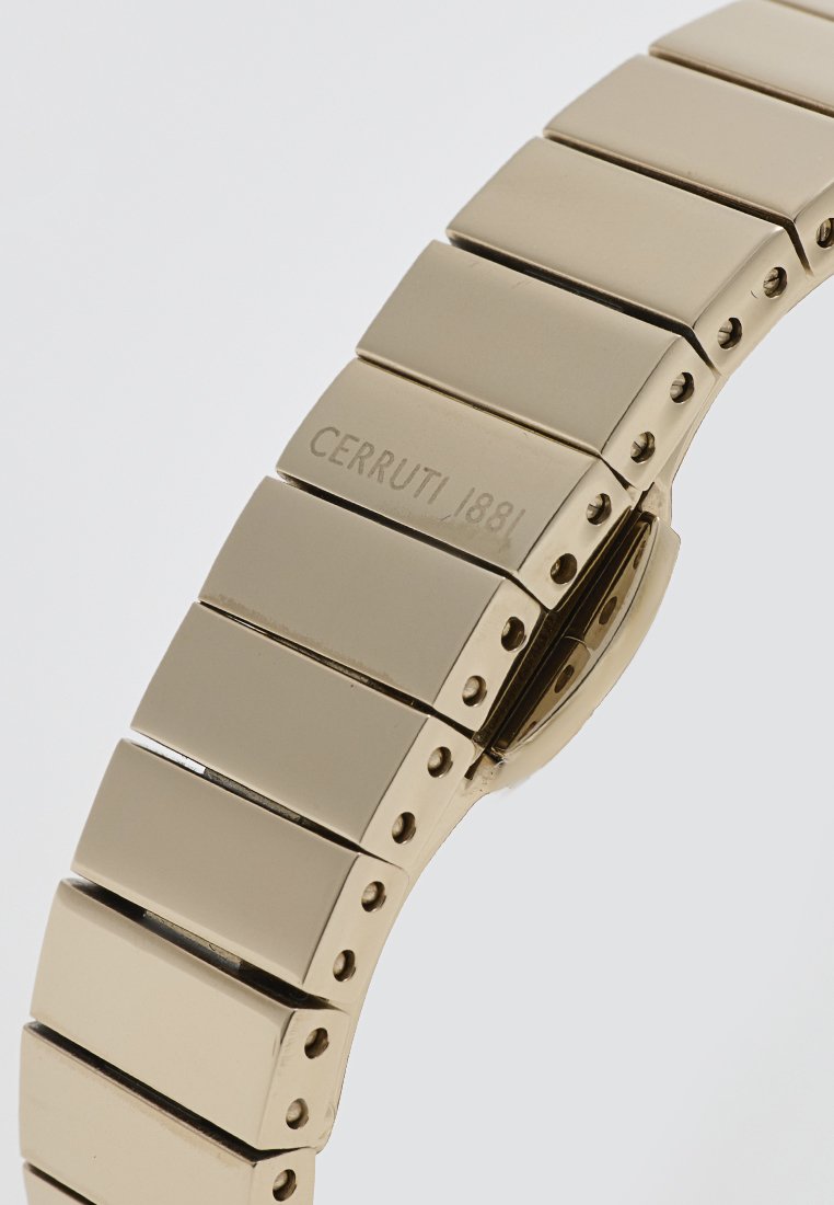 Montre bracelet en métal doré avec des maillons rectangulaires, texture lisse, nom de marque gravé "CERRUTI/1881" et mécanisme de fermoir sécurisé.