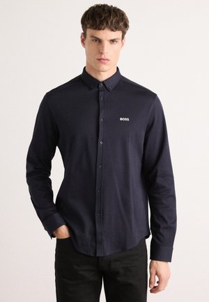 Marineblauwe button-up shirt van gladde stof. Heeft lange mouwen, een kraag en een klein wit 'BOSS' logo op de borst.