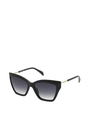 Lunettes de soleil noires forme œil de chat avec verres sombres dégradés et fines touches dorées sur les branches, présentées sous un léger angle sur fond blanc.