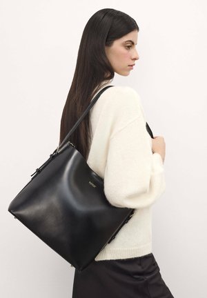 Borsa a spalla in pelle nera con una texture liscia e design minimalista. Presenta un logo dorato e una tracolla regolabile.
