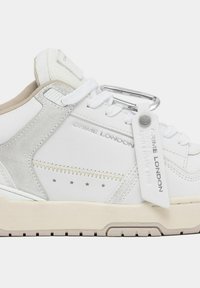 Sneaker alte bianche e beige realizzate in pelle e suede, con hardware metallico, motivo a stella e etichetta con marchio. Suola testurizzata e lacci.