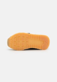 Semelle de chaussure dotée d'une surface en caoutchouc texturé, principalement orange avec un motif en grille, affichant des crampons clairs pour une traction et une durabilité optimales.