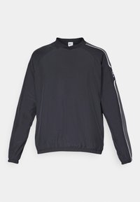 Sort pulloverjakke lavet af letvægtsstof, med rund halsudskæring, elastiske manchetter og hvide sidelister som accent.