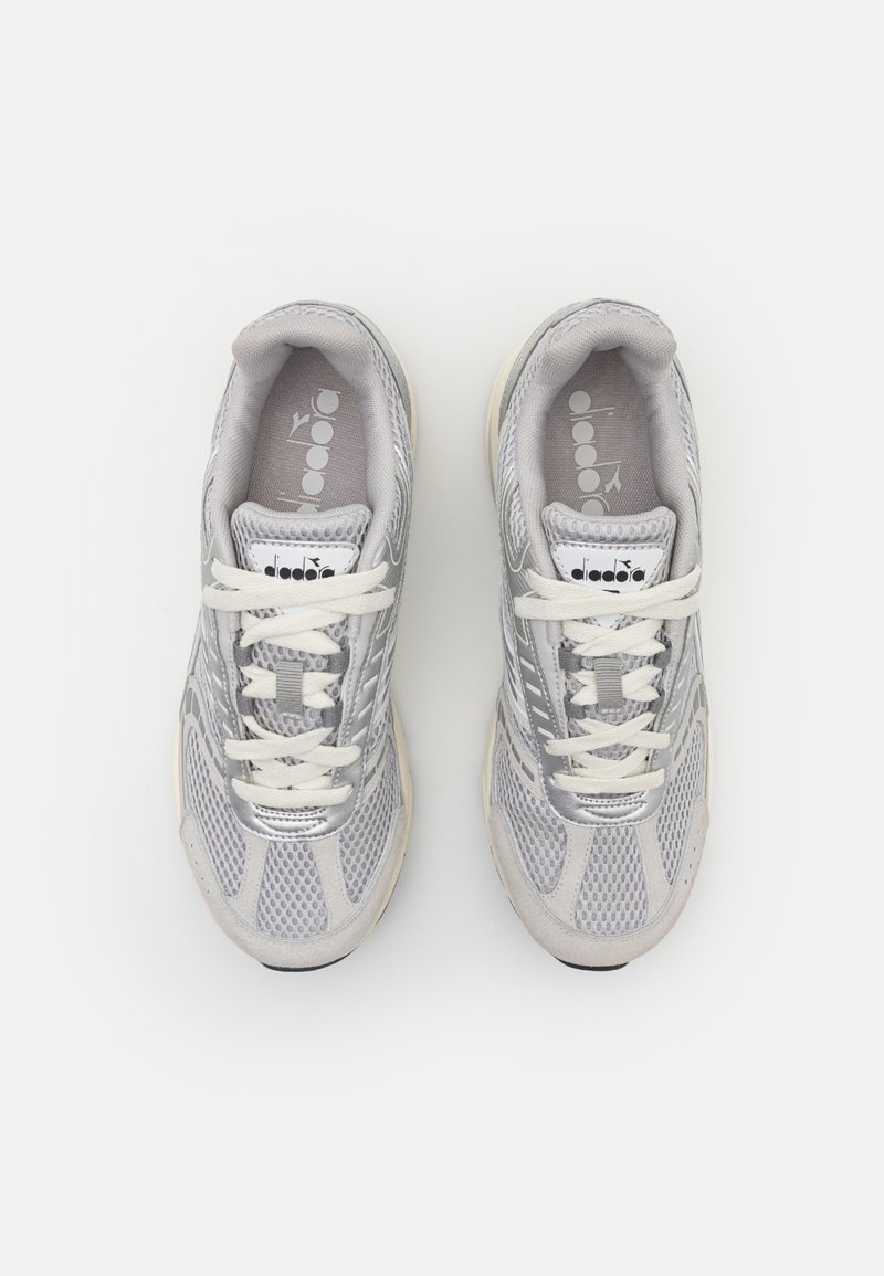 Grijze sport sneakers met een bovenwerk van mesh en suède accenten. Witte veters, gewatteerde kraag en een gestructureerde zool. Logo op de tong. Minimalistisch ontwerp.