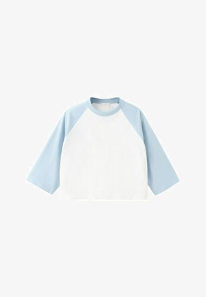 T-shirt blanc à col rond avec manches longues raglan bleu clair et col assorti, présenté à plat sur un fond blanc.