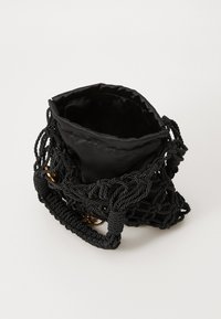 Zwarte handtas met een gevlochten touwontwerp, satijnen interieur, trekkoordsluiting en accenten in goudkleurig beslag.