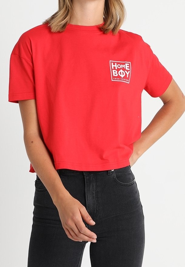 Camiseta corta roja de algodón con mangas cortas. Presenta un parche de logo blanco con la inscripción "HOME BOY" en la parte izquierda del pecho.